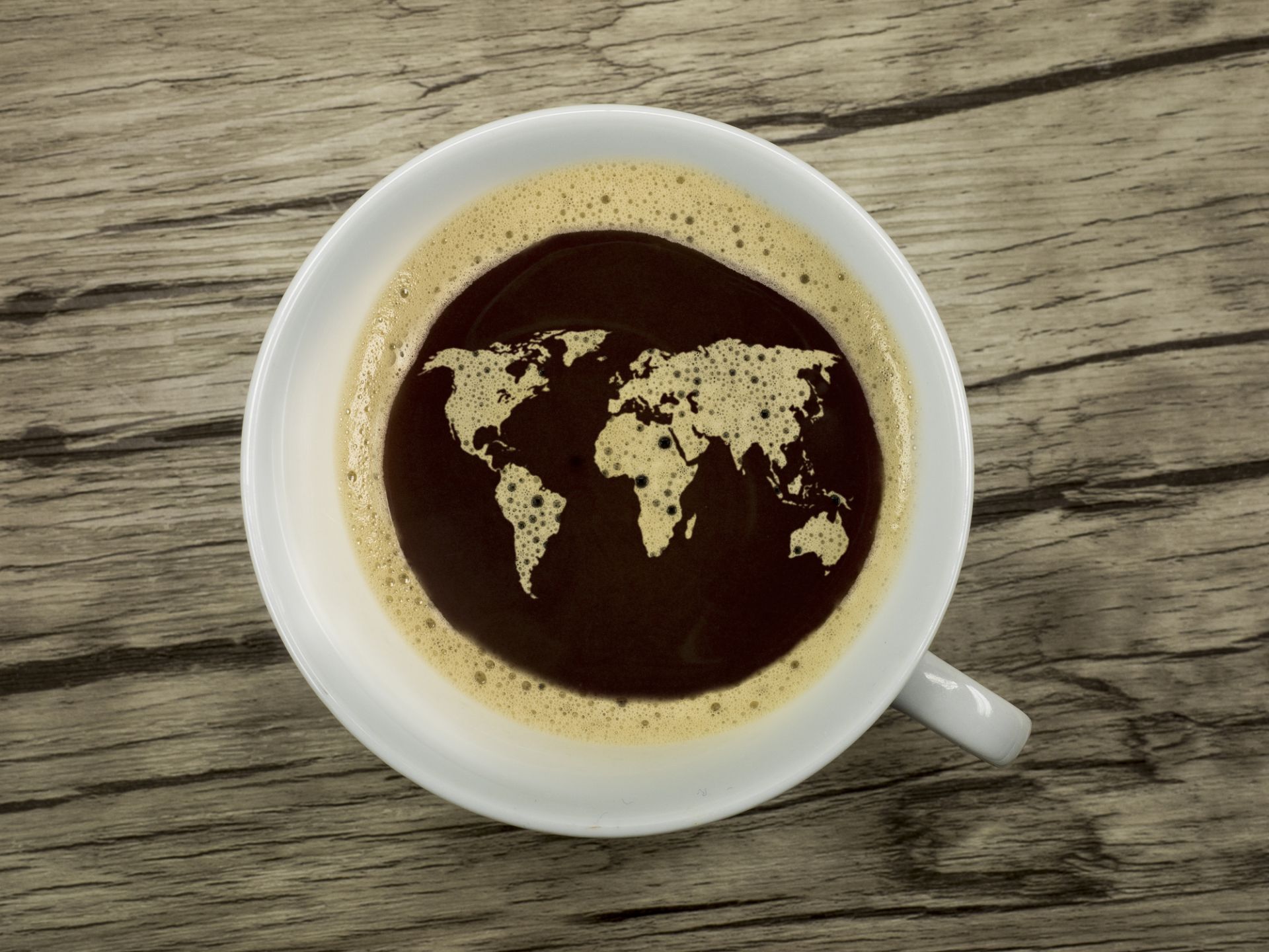 A cup of coffee with a world map as latte art