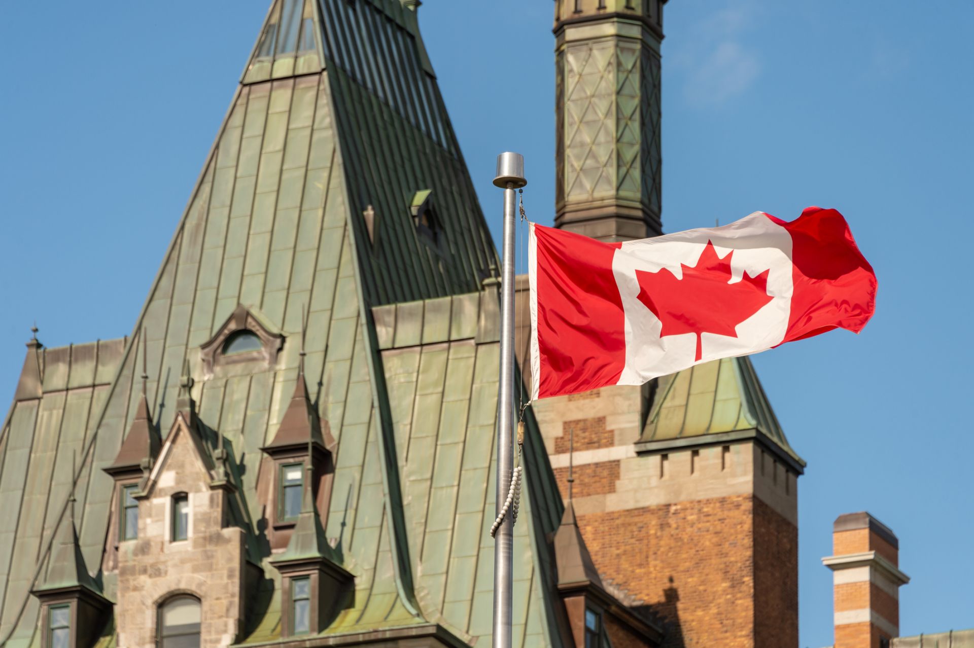 A Canadian flag flies in front of the country's parliment buildings